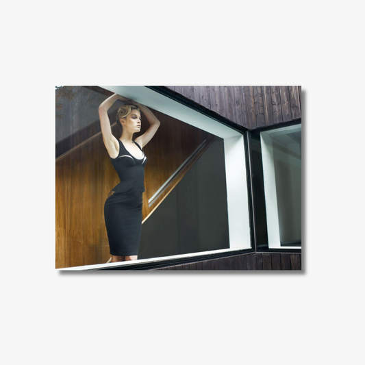 Woman in a black dress standing in a modern architectural setting