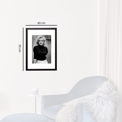 Framed black and white portrait of a woman on a white wall with dimensions indicated.