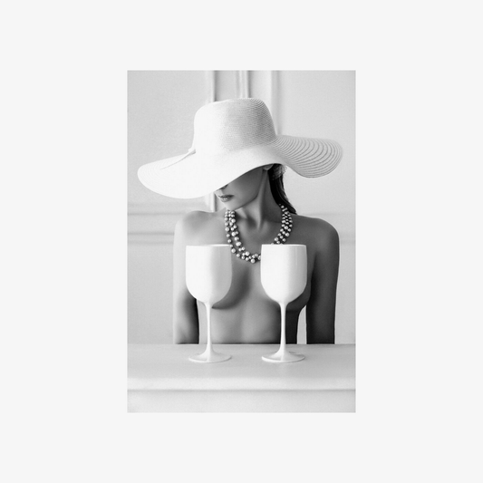 Mannequin head wearing a wide-brimmed hat with two white wine glasses on a light gray background