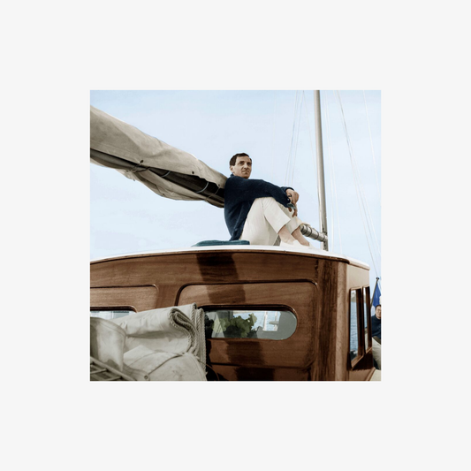 Man sitting on a sailboat with a clear sky background