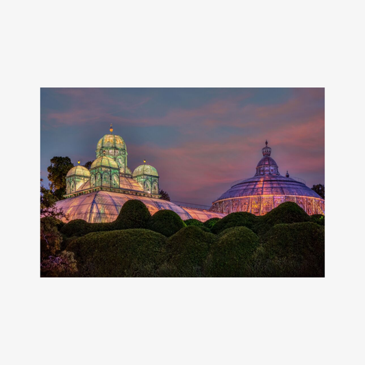Two domed structures illuminated against a twilight sky with pink and purple hues.