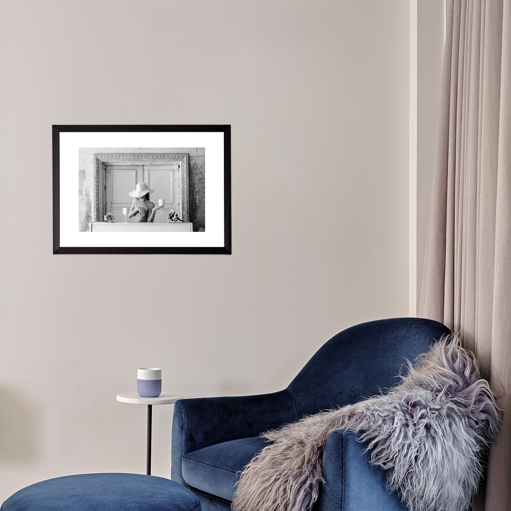 Blue armchair with a fur throw in a room with a framed black and white photo on the wall.