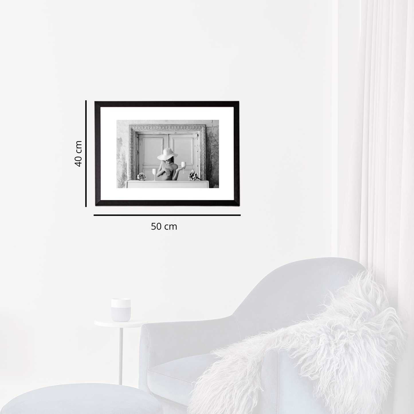 Framed black and white photo on a white wall with dimensions indicated