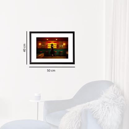 Framed artwork of a silhouette against a colorful background, displayed on a white wall with dimensions indicated.