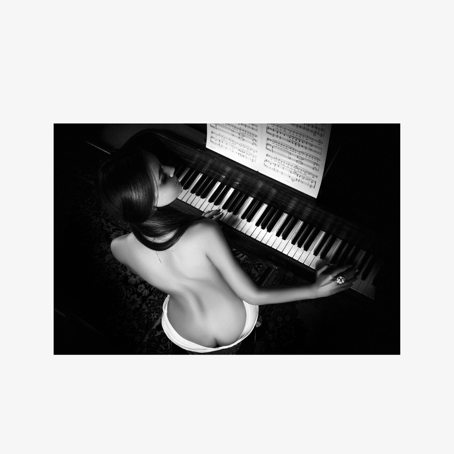 Black and white image of a person playing a piano