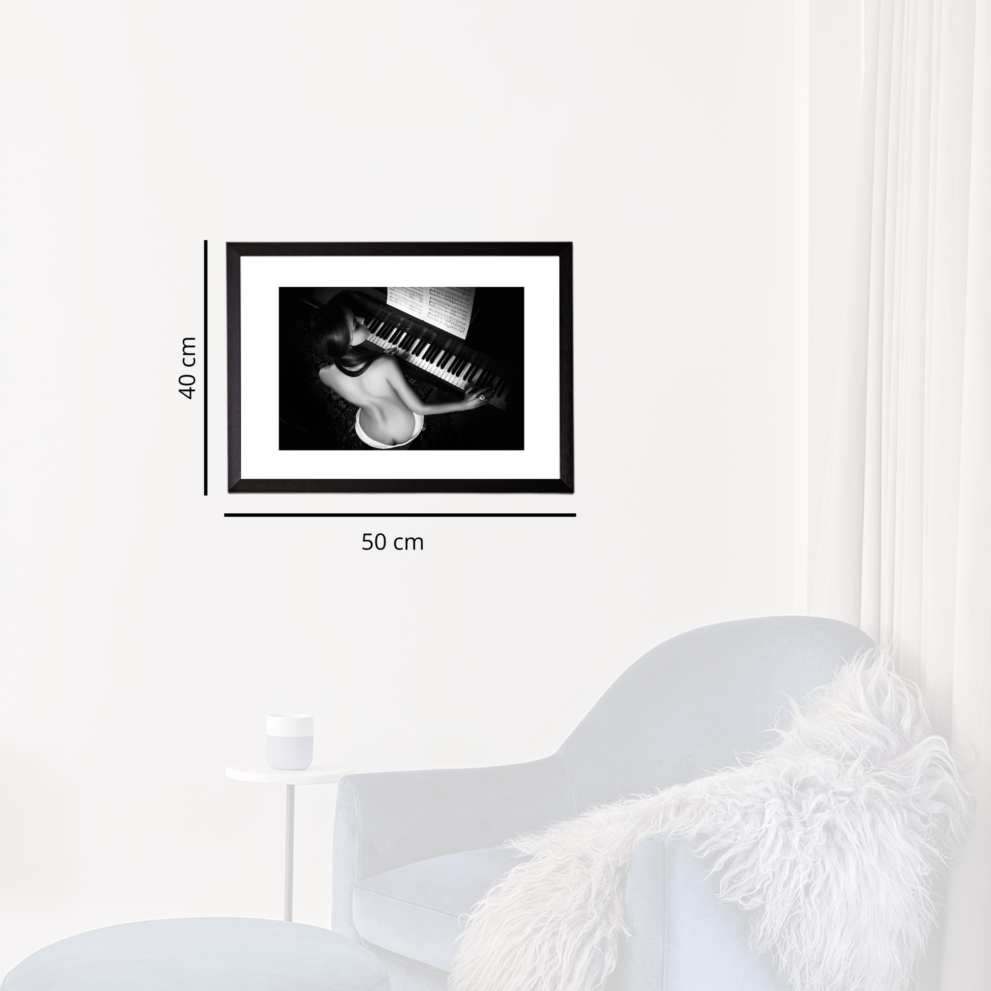 Framed black and white artwork on a white wall with dimensions indicated.