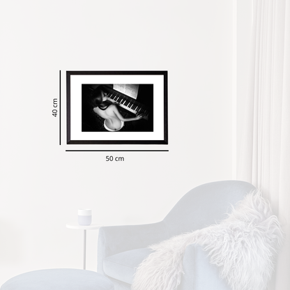 Framed black and white artwork on a white wall with dimensions indicated.