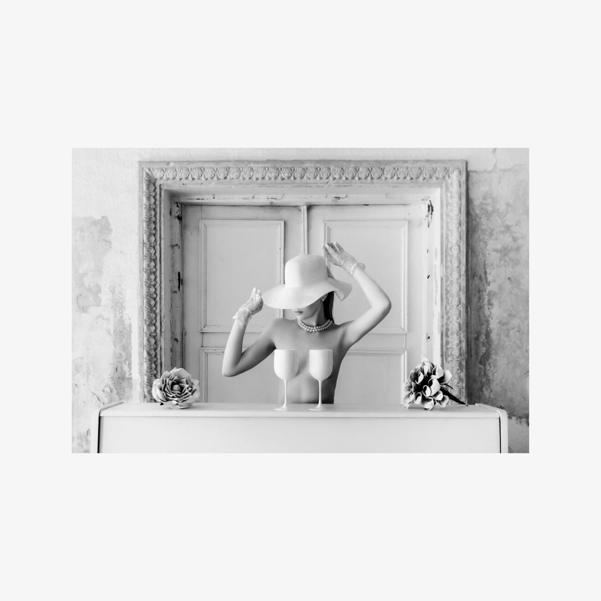 Black and white photo of a woman in a large frame with decorative elements.