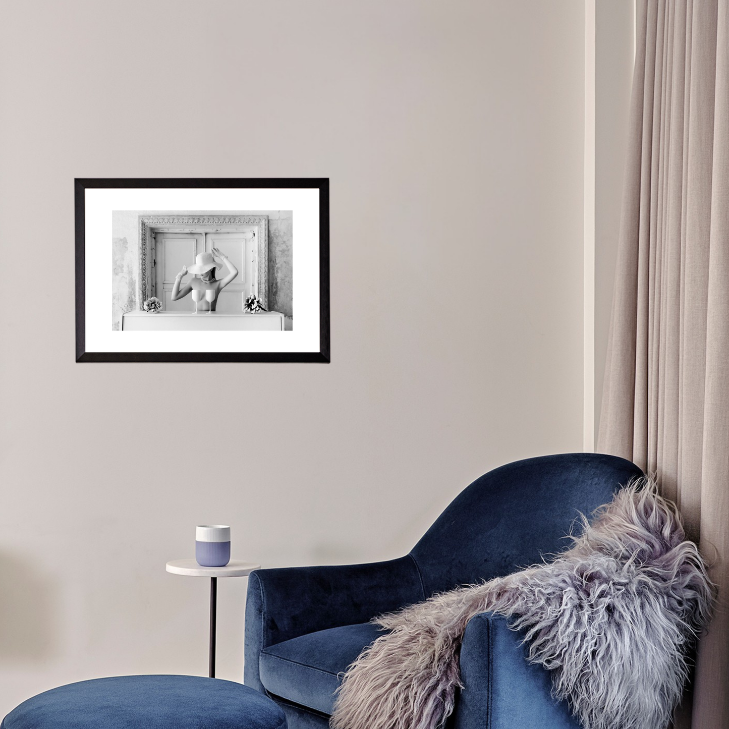 Blue armchair with a fur throw in a room with a framed black and white photo on the wall.