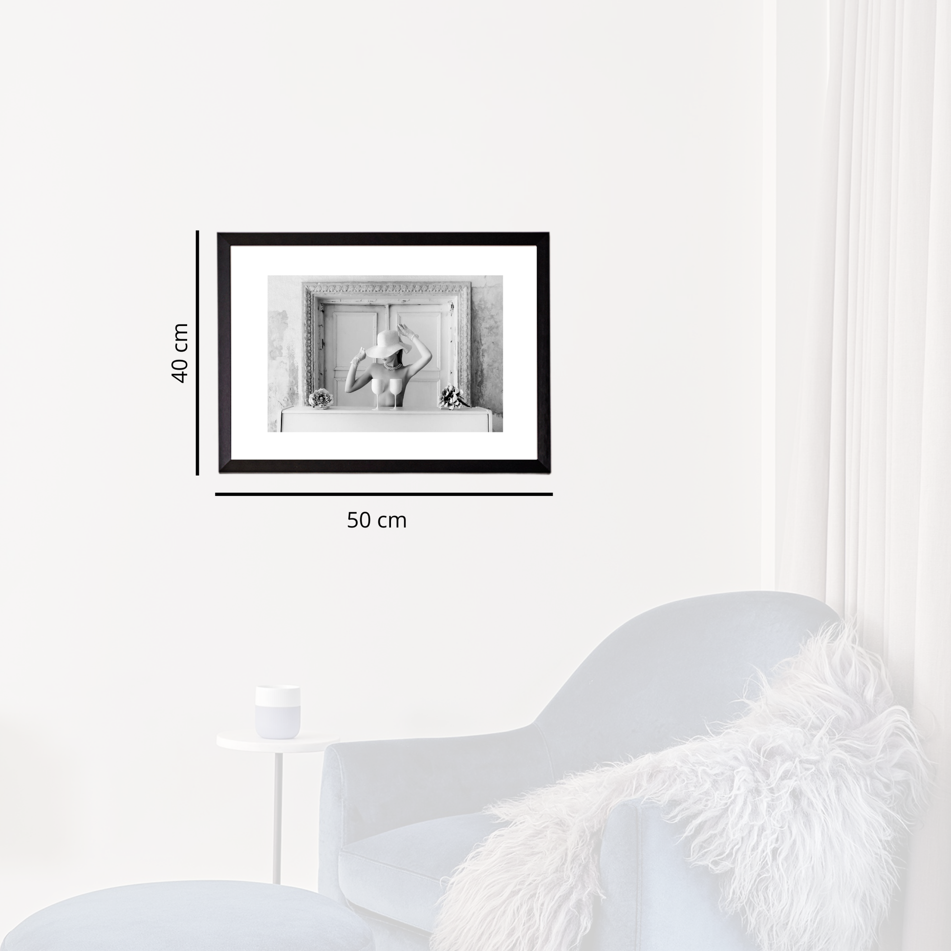 Framed black and white artwork on a white wall with dimensions indicated.