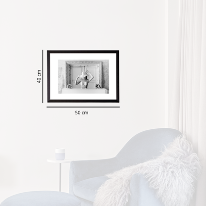 Framed black and white artwork on a white wall with dimensions indicated.