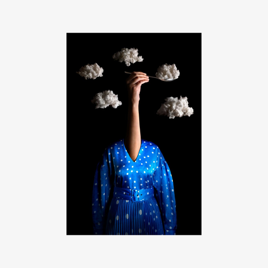 Person in a blue dress with cloud-like shapes in the background