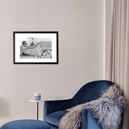 Blue armchair with a fur throw in a room with a framed black and white photo on the wall.