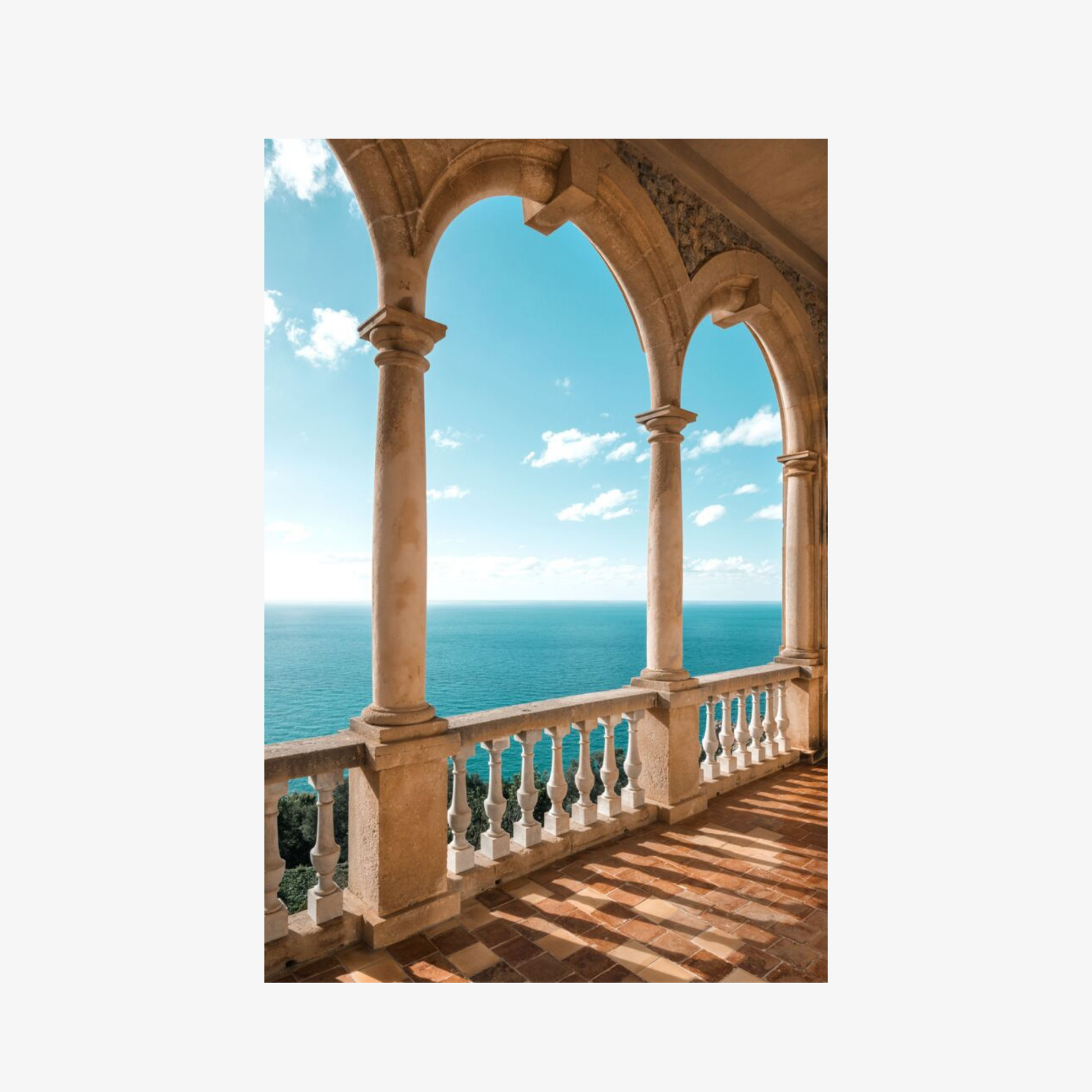 Balcony with arches overlooking a blue ocean and sky