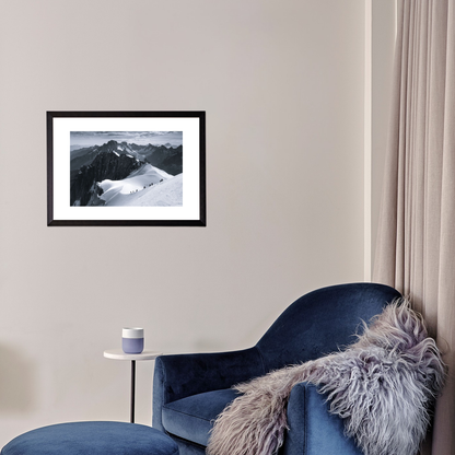 Blue armchair with a fur throw in a room with a framed black and white photo of mountains on the wall.