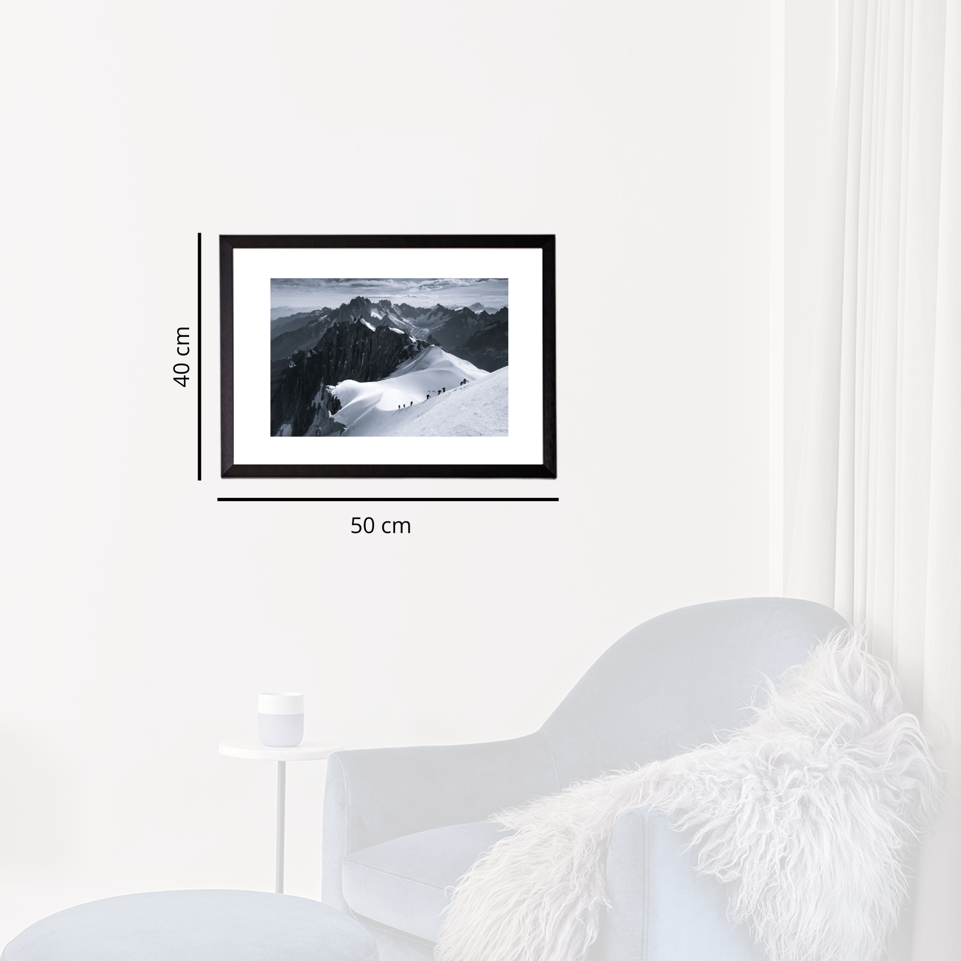 Framed black and white mountain landscape on a white wall with dimensions indicated.