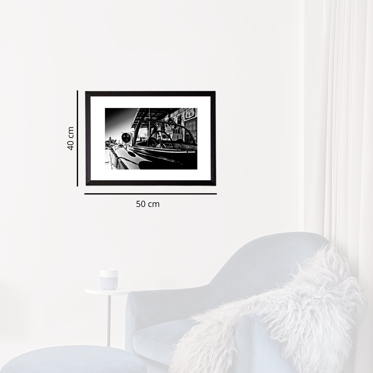 Framed black and white photo on a wall next to a white chair
