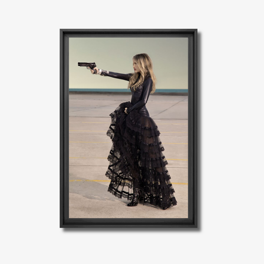 Framed artwork of a woman in a black dress holding a gun in an indoor setting.