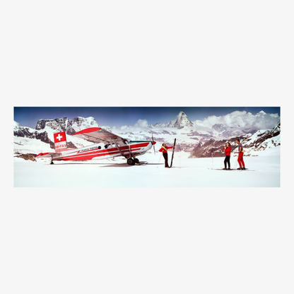 Small red and white airplane on a snowy mountain with people nearby