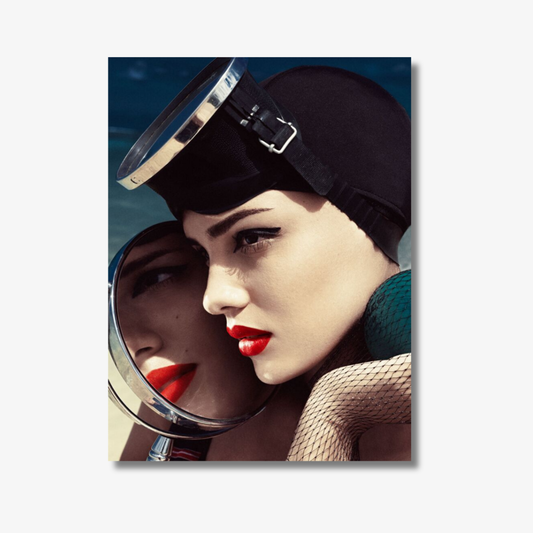 Woman wearing a black helmet with a reflective visor, looking into a mirror.