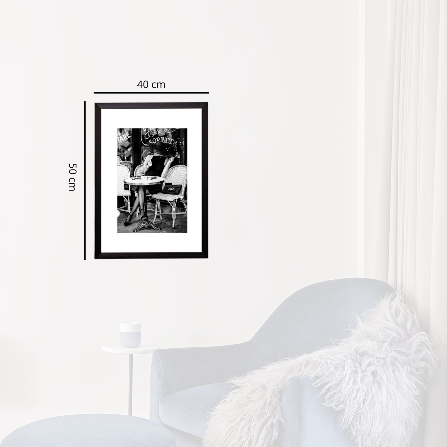 Framed black and white photo on a white wall with dimensions indicated