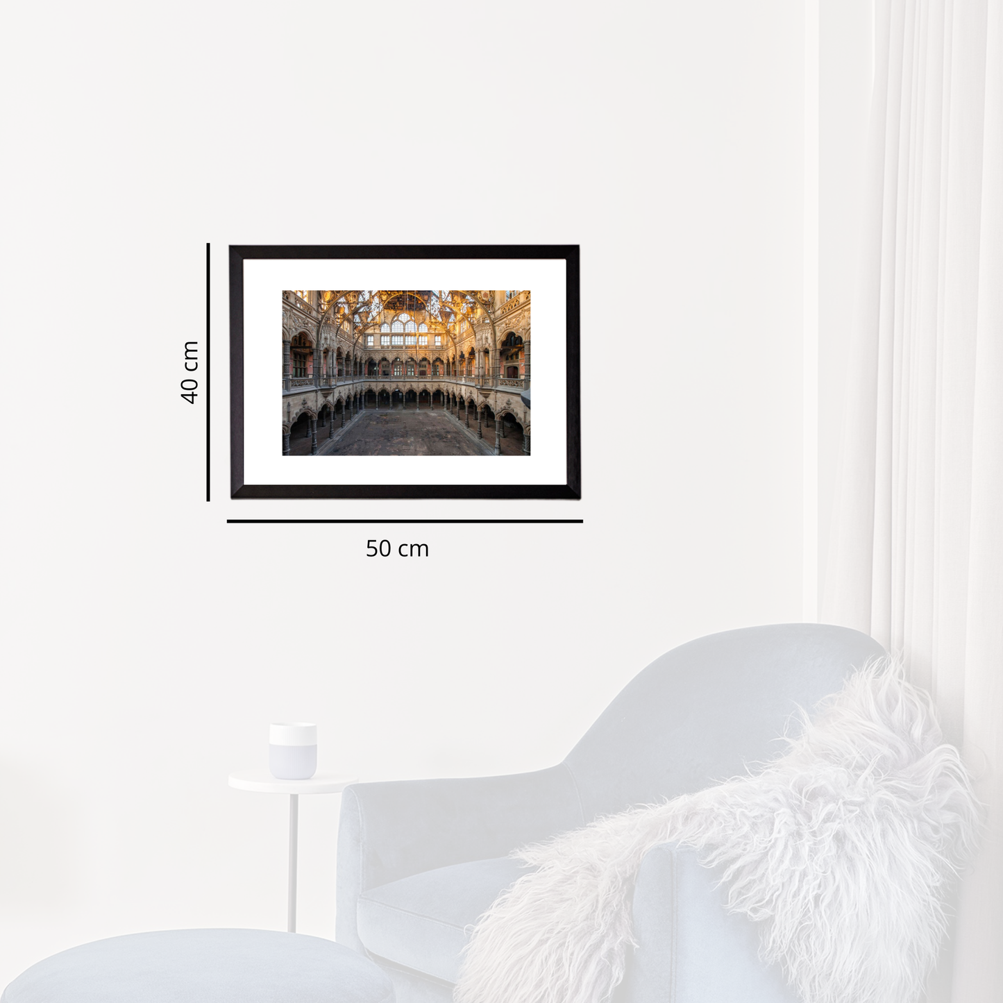 Framed artwork on a white wall with dimensions indicated, next to a modern white chair.