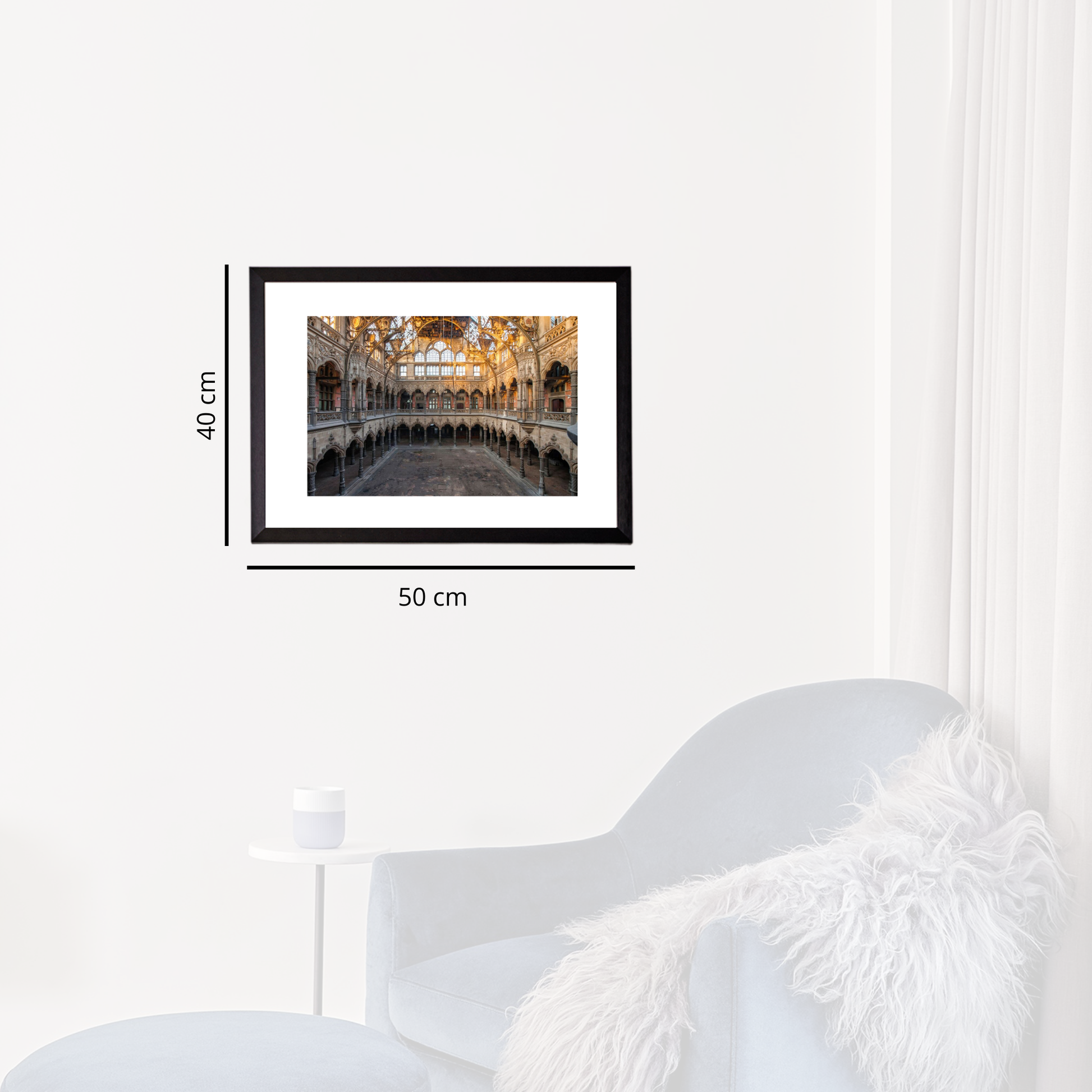 Framed artwork on a white wall with dimensions indicated, next to a modern white chair.