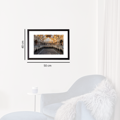 Framed artwork on a white wall with dimensions indicated, next to a modern white chair.
