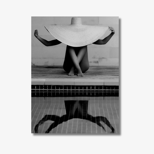 Person with a wide-brimmed hat standing by a pool