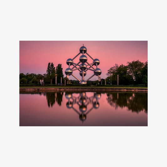 Spherical structure reflected in water with a pink sky