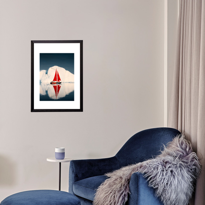 Framed artwork of a sailboat on water with clouds, displayed above a blue armchair in a room.