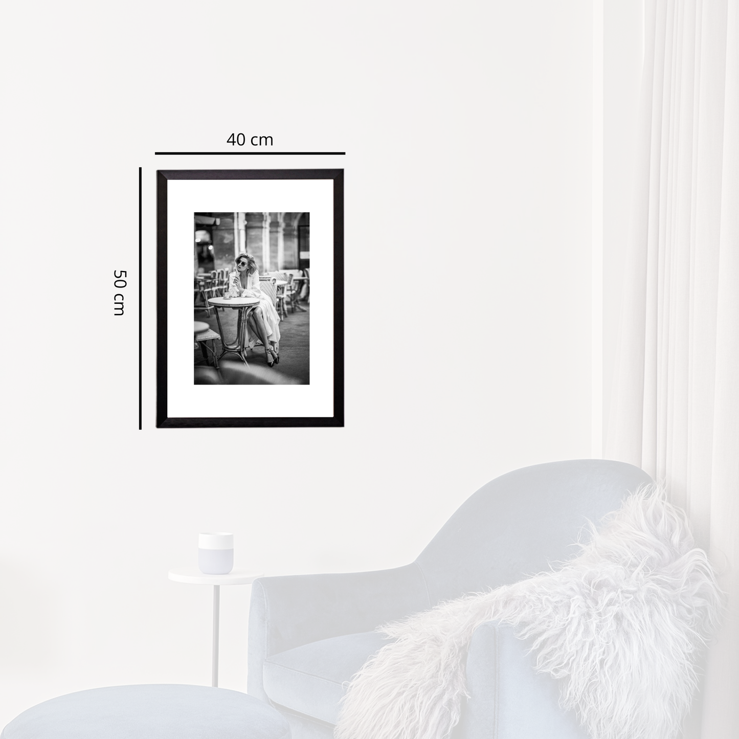 Framed black and white photo on a white wall with dimensions indicated