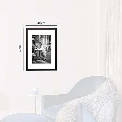 Framed black and white photo on a white wall with dimensions indicated