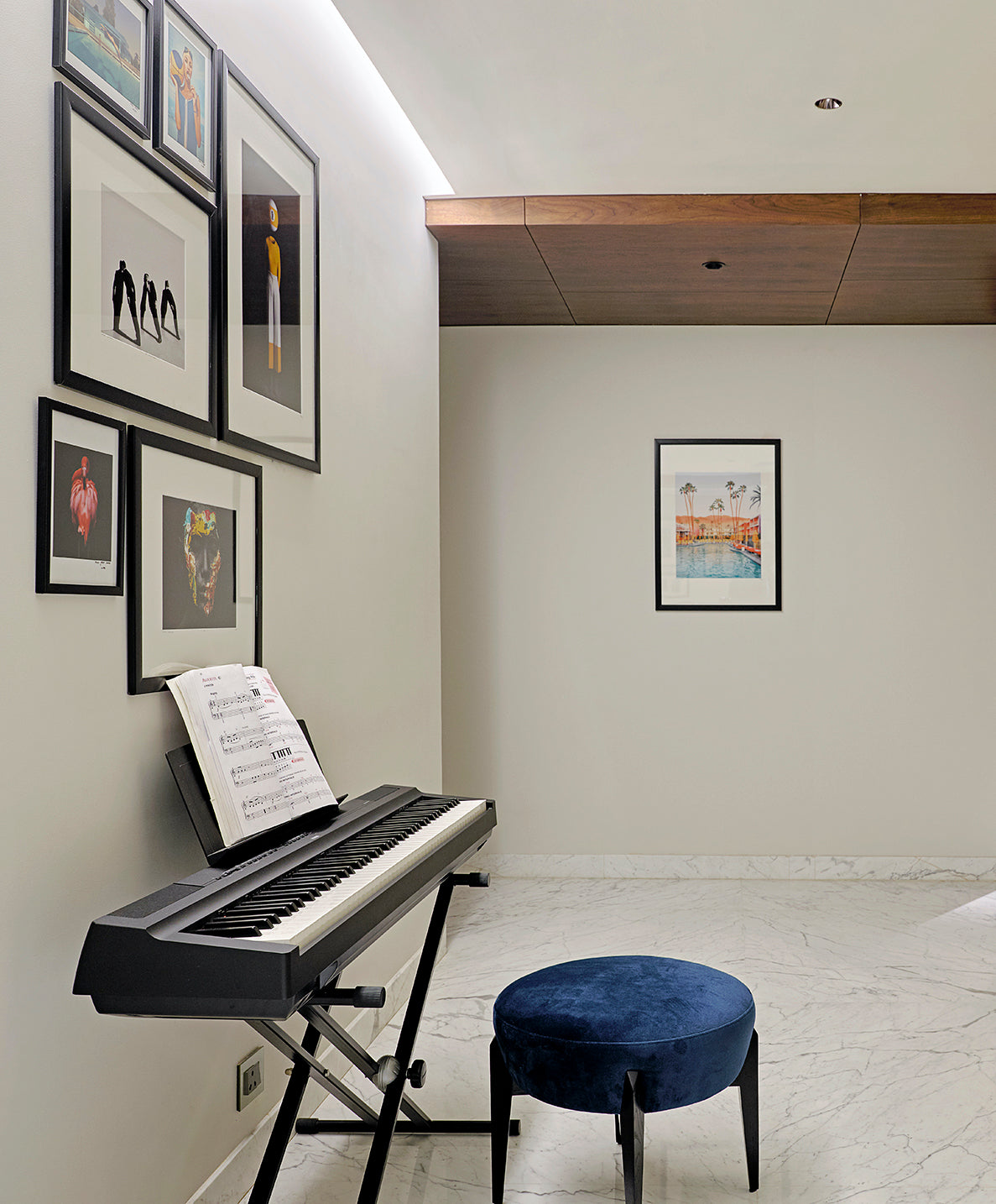 Digital piano in a living room with framed pictures on the gallery wall ideas for living room decor